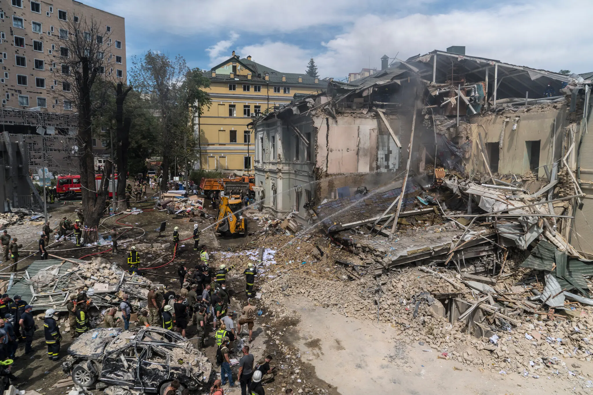 Пожежники полили шлангом розплющений кут будівлі після російського ракетного удару по дитячій лікарні в Києві в понеділок.